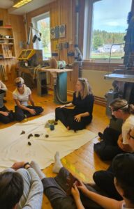 Victoria Anne Collis, MA guiding the Year 6 children through the forest in a guided visualisation -grounding, breathing, touching, and passing gifted objects from the special forests of Nordingrå, including a soapstone from the mountain – to help bring us back into the feeling, the sense within, before we got joyfully messy with inks! Nordingrå Vallen School, September 2025.